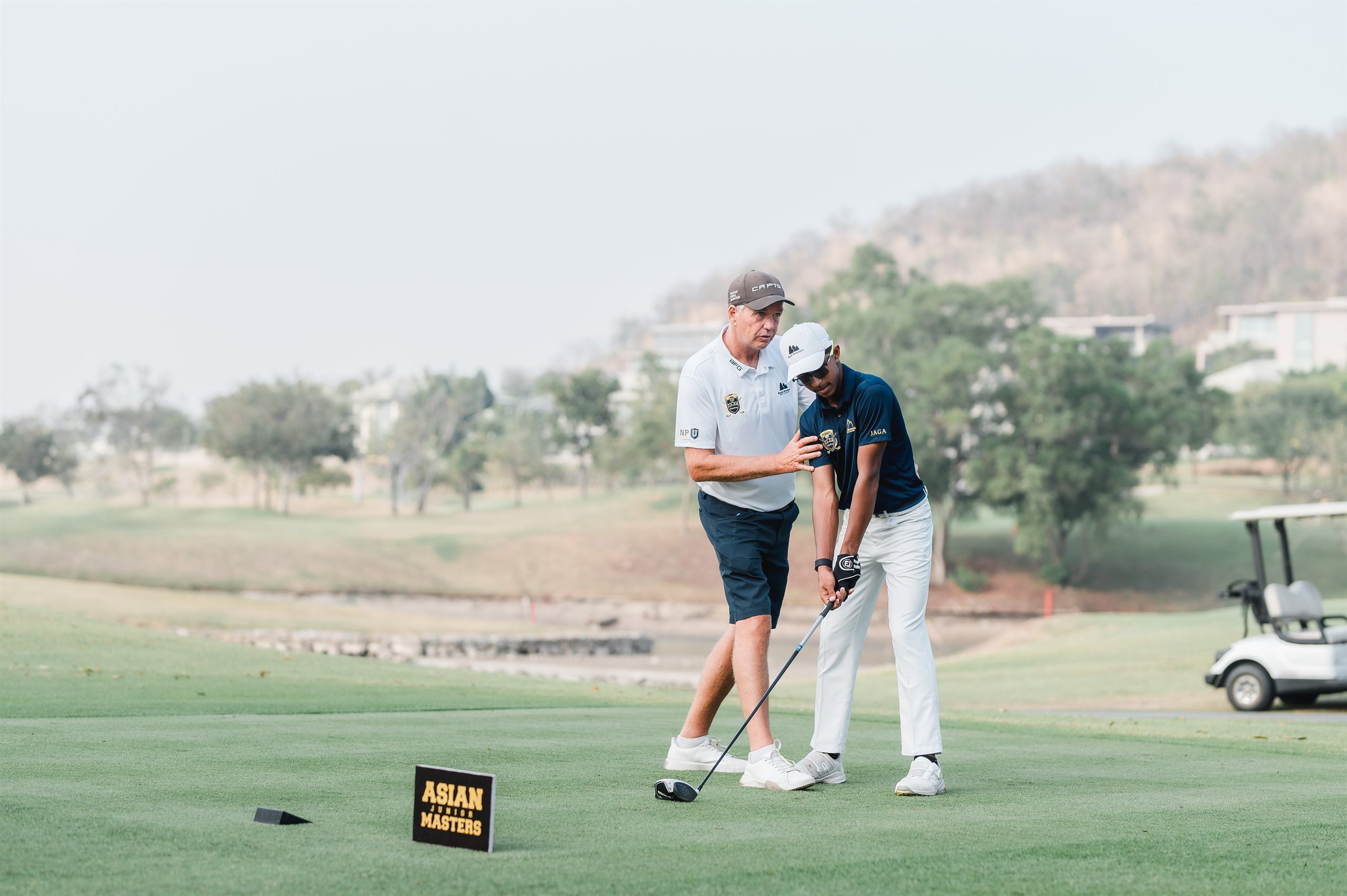 JAGA coach guiding a student-athlete on the tee